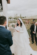 a woman in a wedding dress standing next to a man in a suit