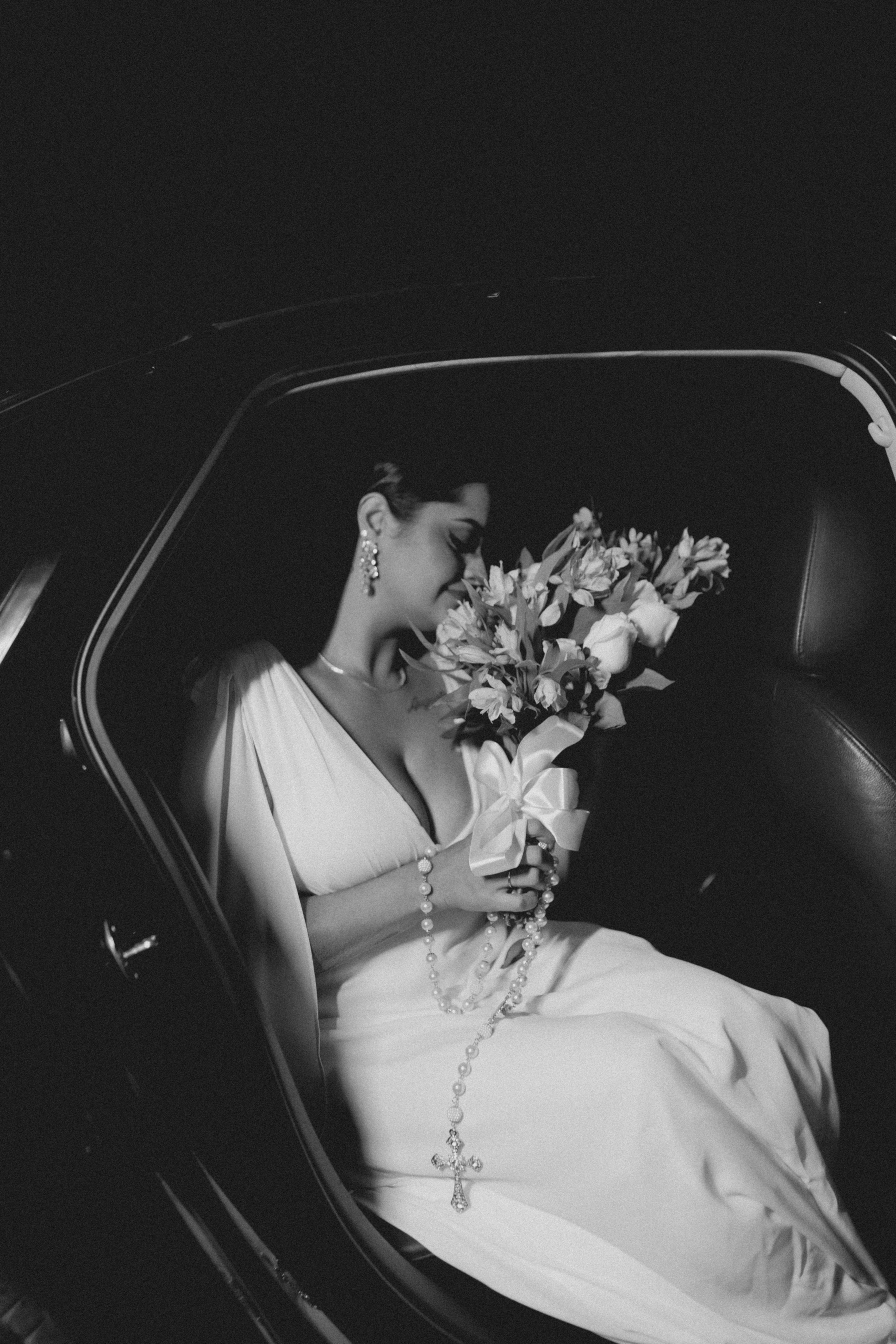 a woman in a white dress sitting in a car