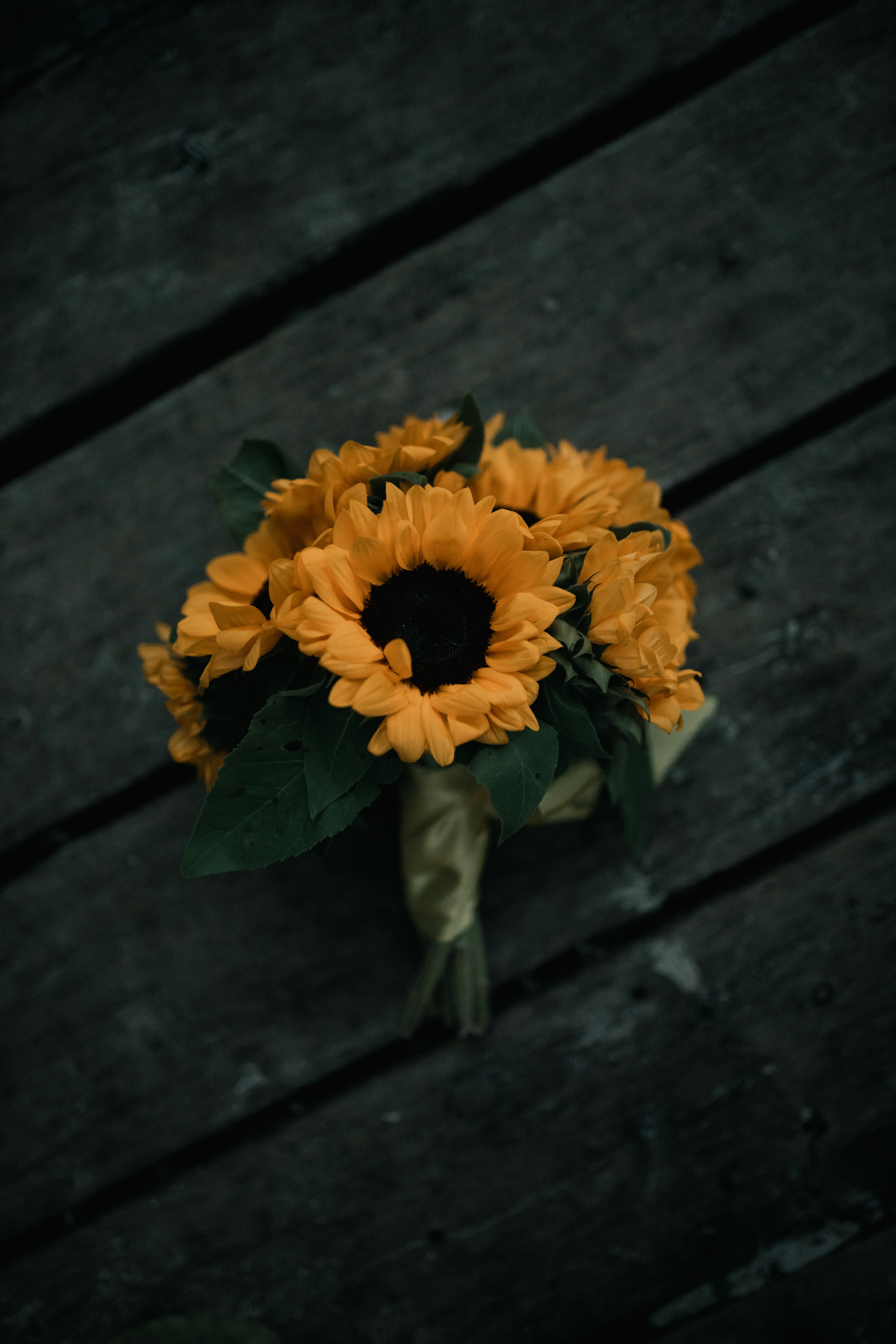 a bouquet of sunflowers on a wooden surface