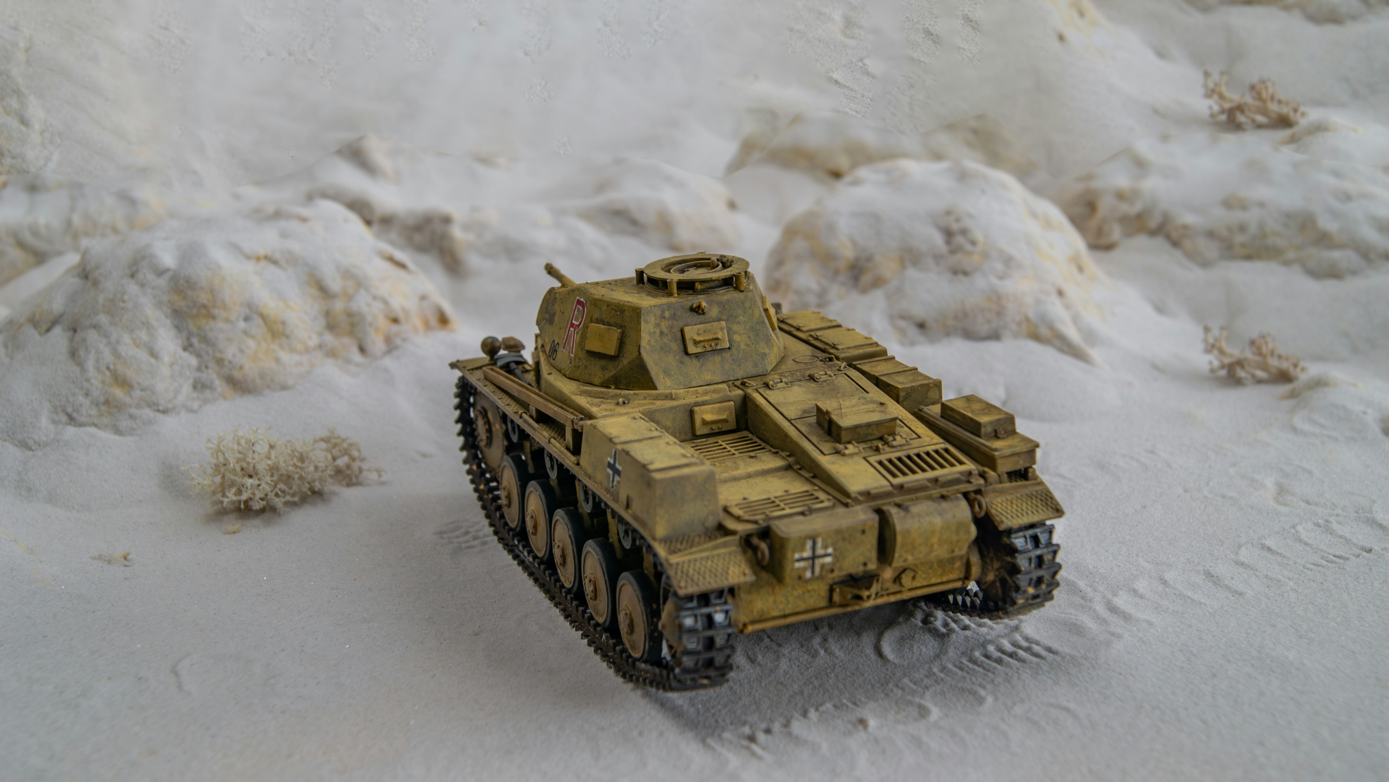 a toy army tank is in the snow