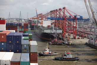 a tug boat in the water next to a large cargo ship