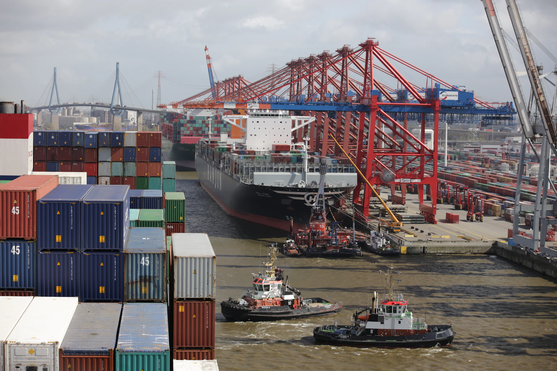 Tug boat guiding a large cargo ship into port