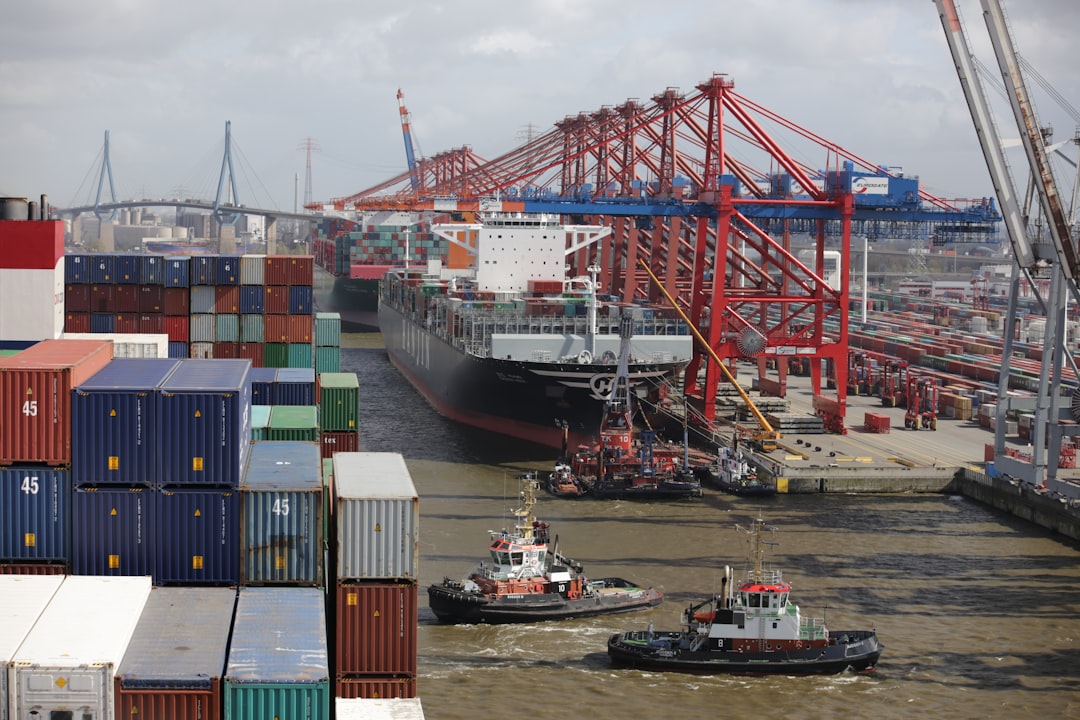 a tug boat in the water next to a large cargo ship,