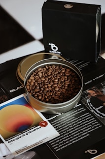 a metal bowl filled with coffee beans on top of a table