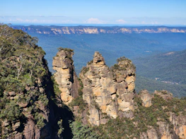 three rock formations in the middle of a mountain range