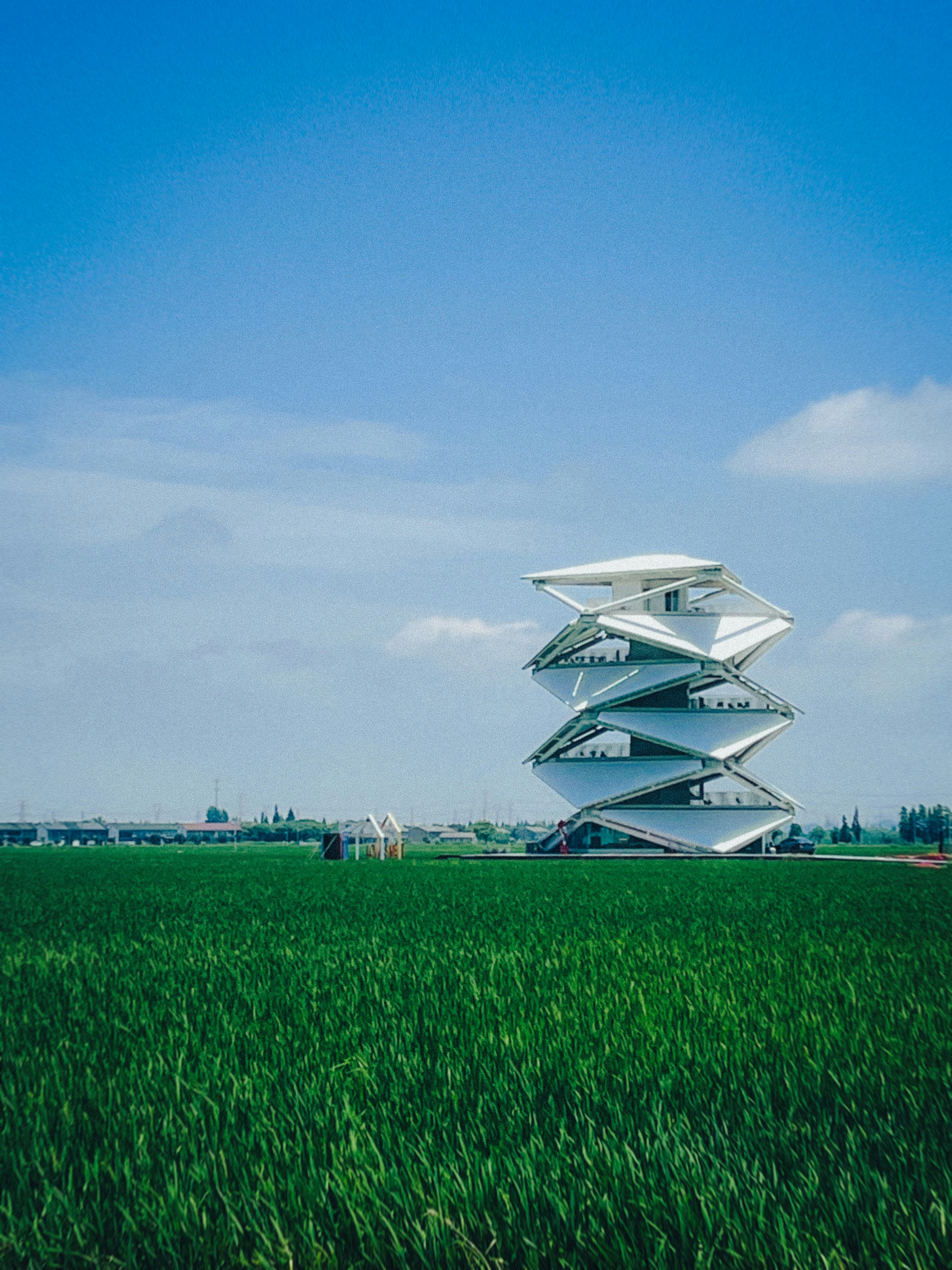 um edifício alto sentado no meio de um campo verde exuberante