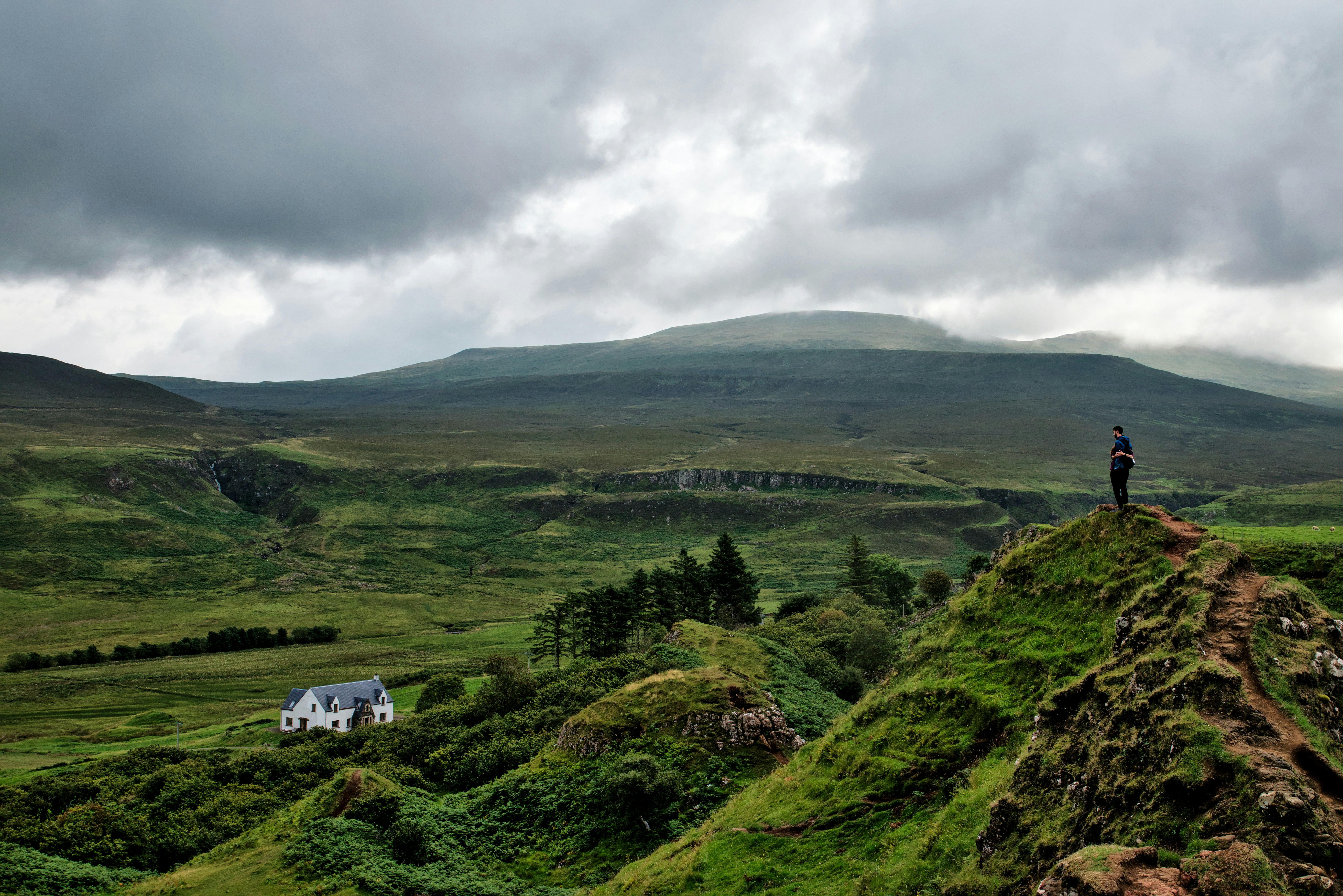 a person standing on top of a lush green hillside