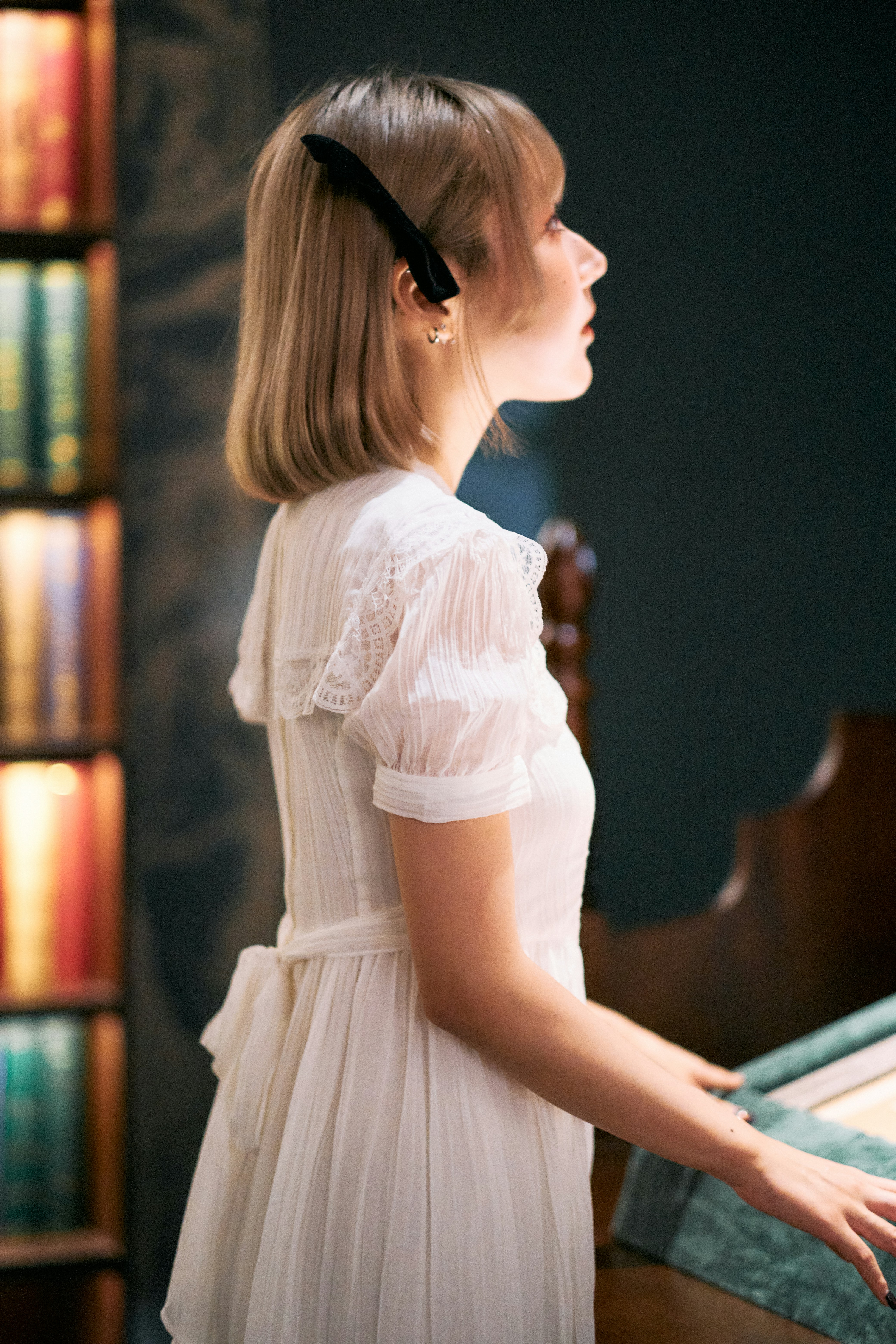 A woman in a white dress standing in front of a piano photo – Free Girl ...