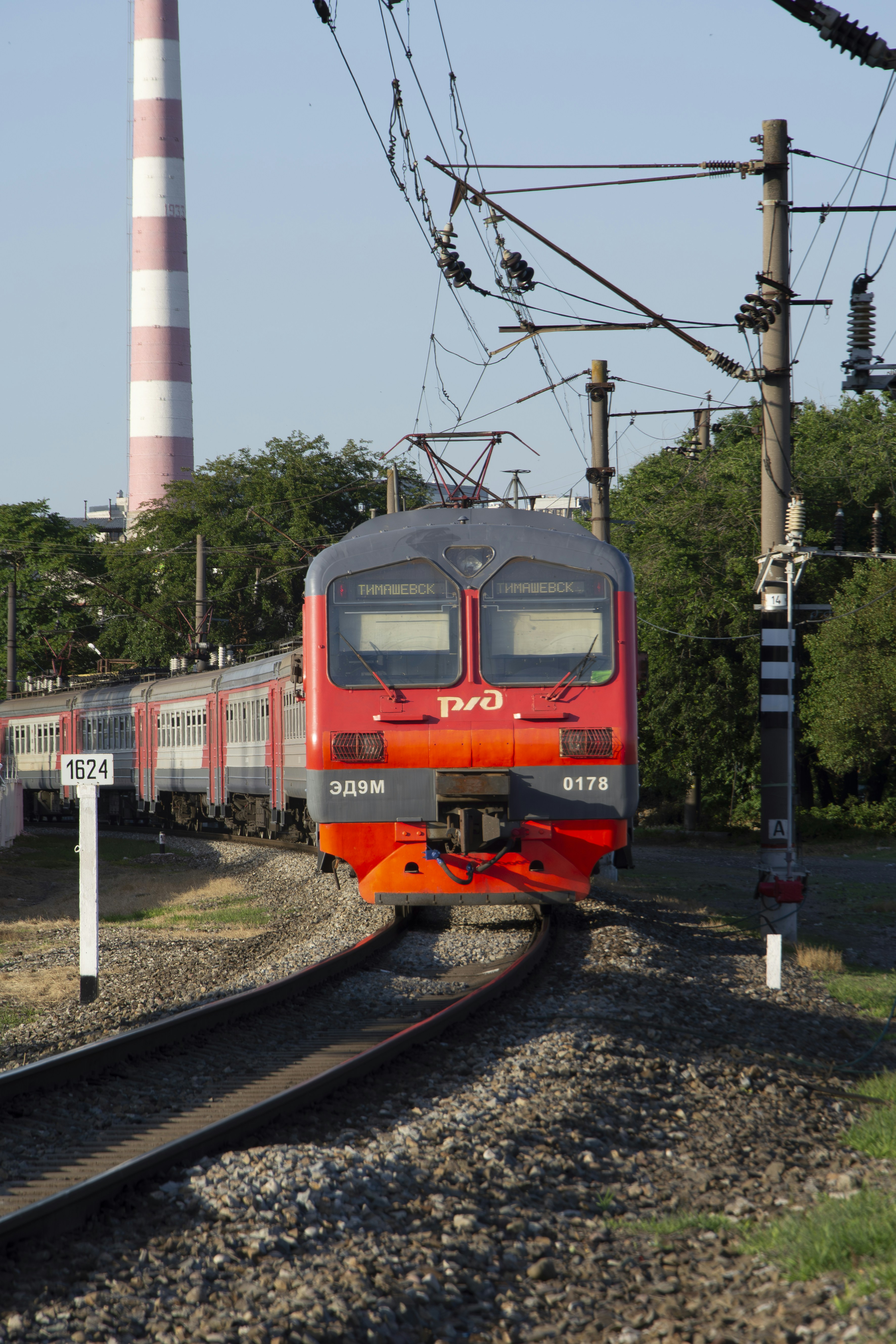 a red train traveling down train tracks next to a tower