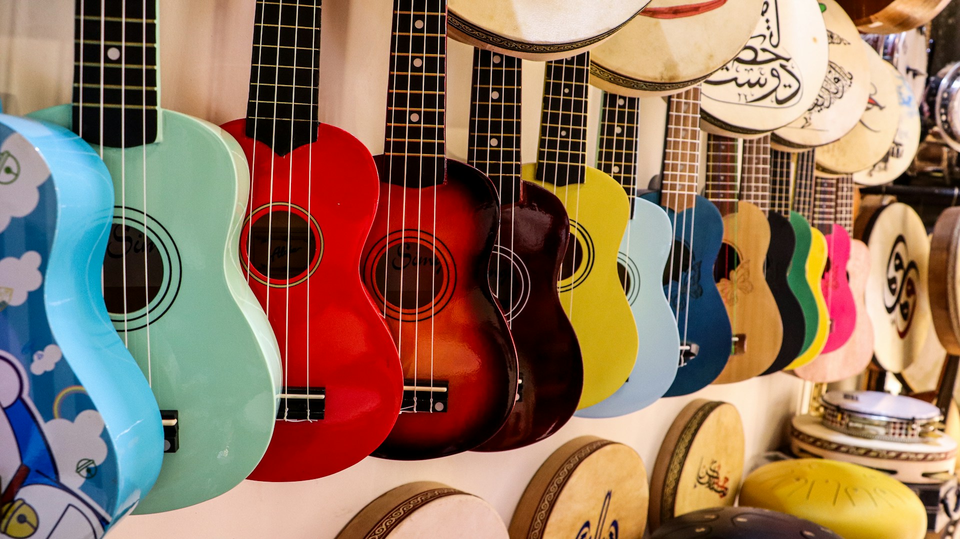 A row of colorful guitars hanging on a wall