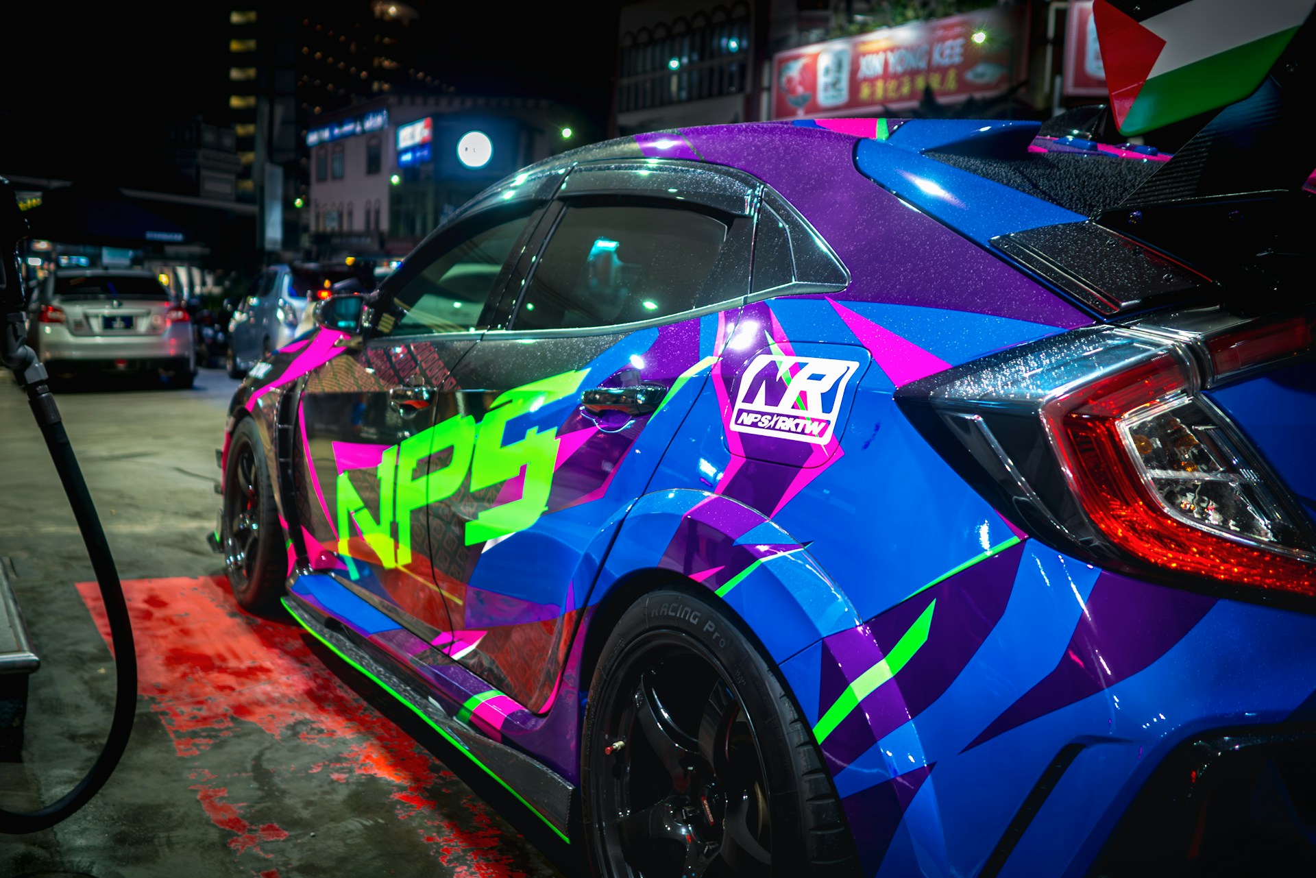 A colorful car is parked at a gas pump