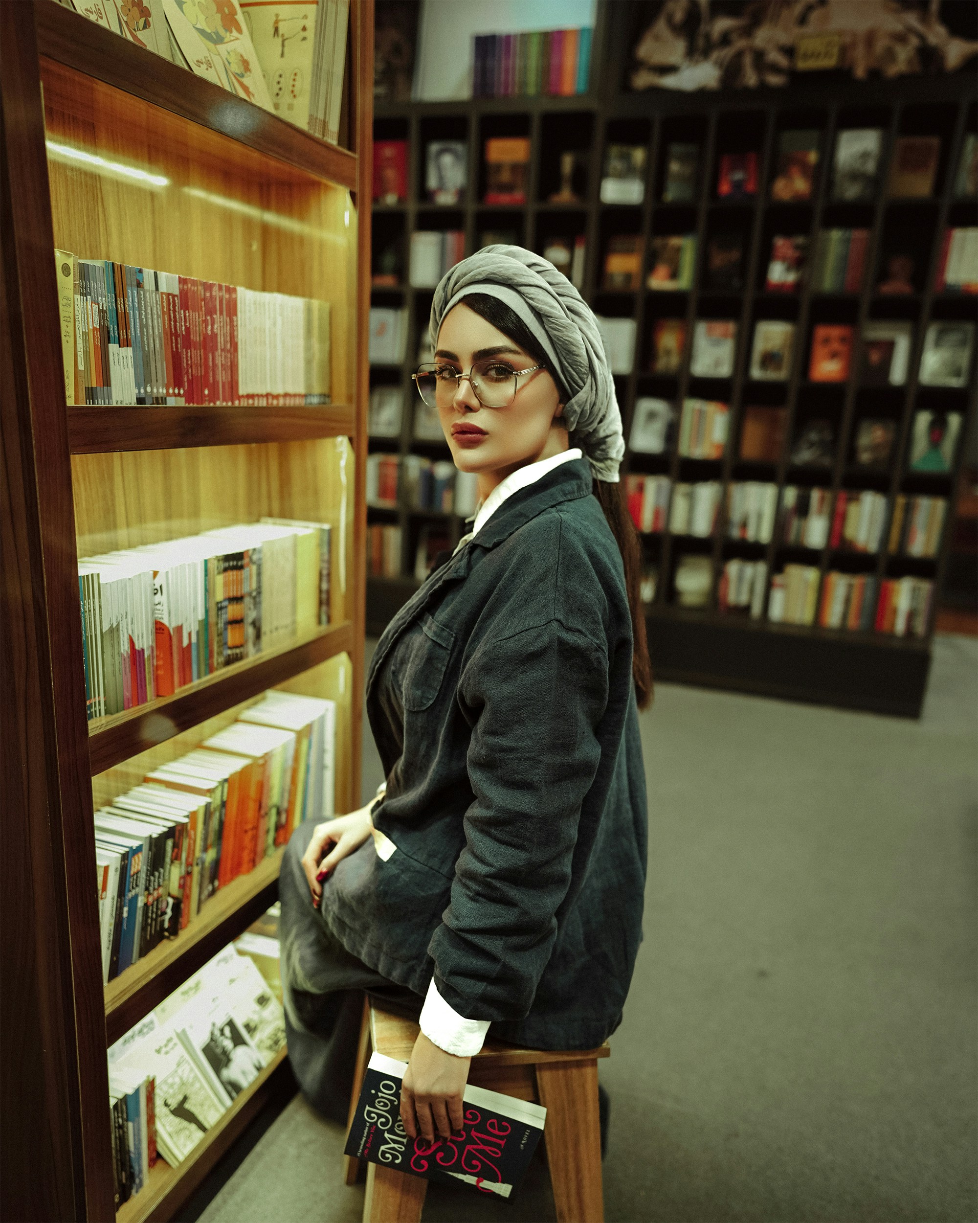 a woman standing in front of a book shelf
