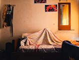 a bed covered with a blanket in a room