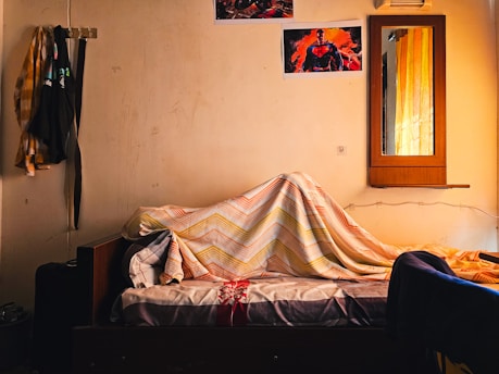 a bed covered with a blanket in a room