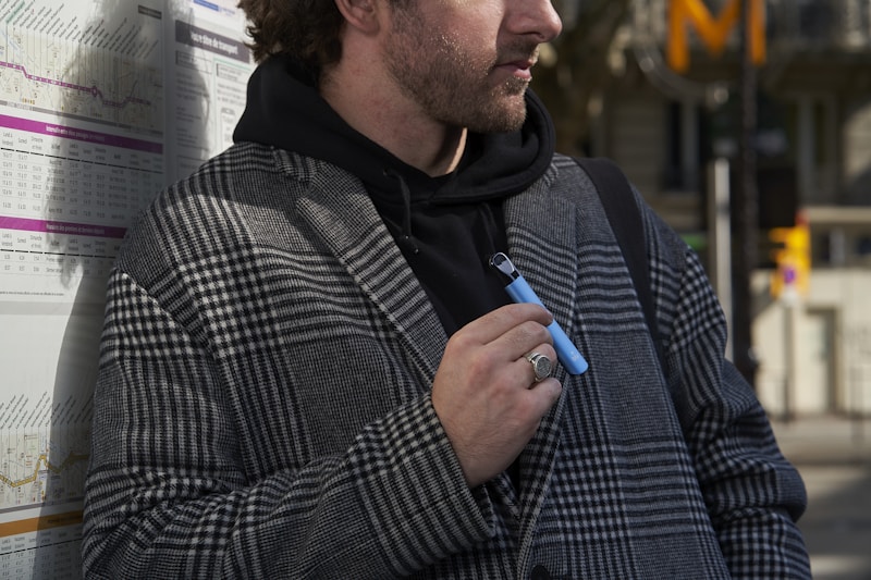 a man standing next to a wall with a pen in his hand