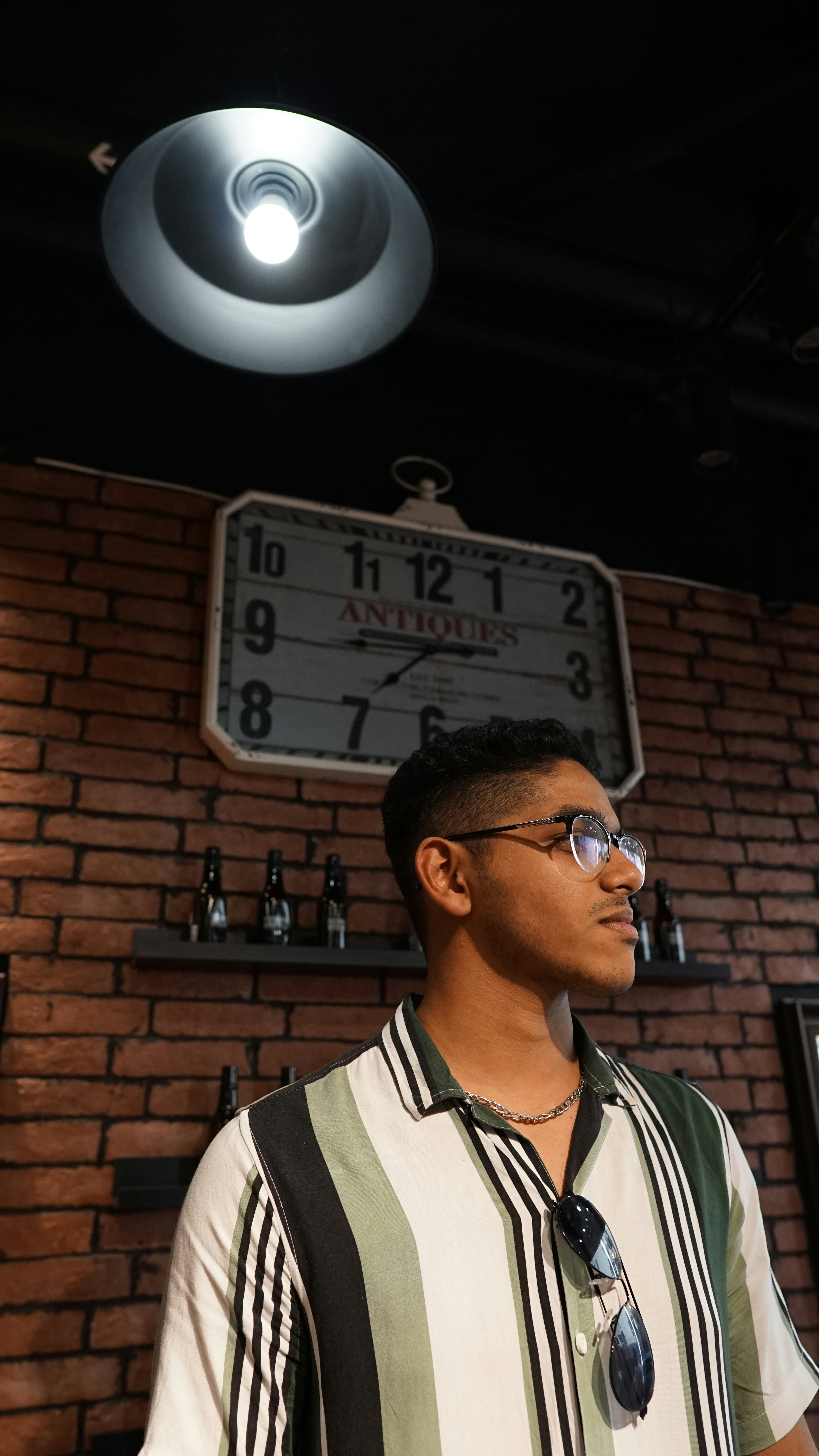 a man standing in front of a brick wall