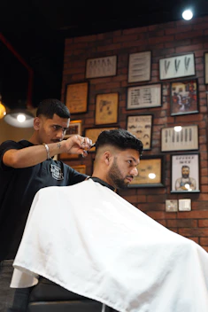 a man getting his hair cut at a barber shop