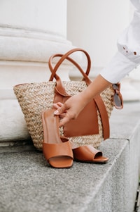 A woman's hand is holding a brown purse