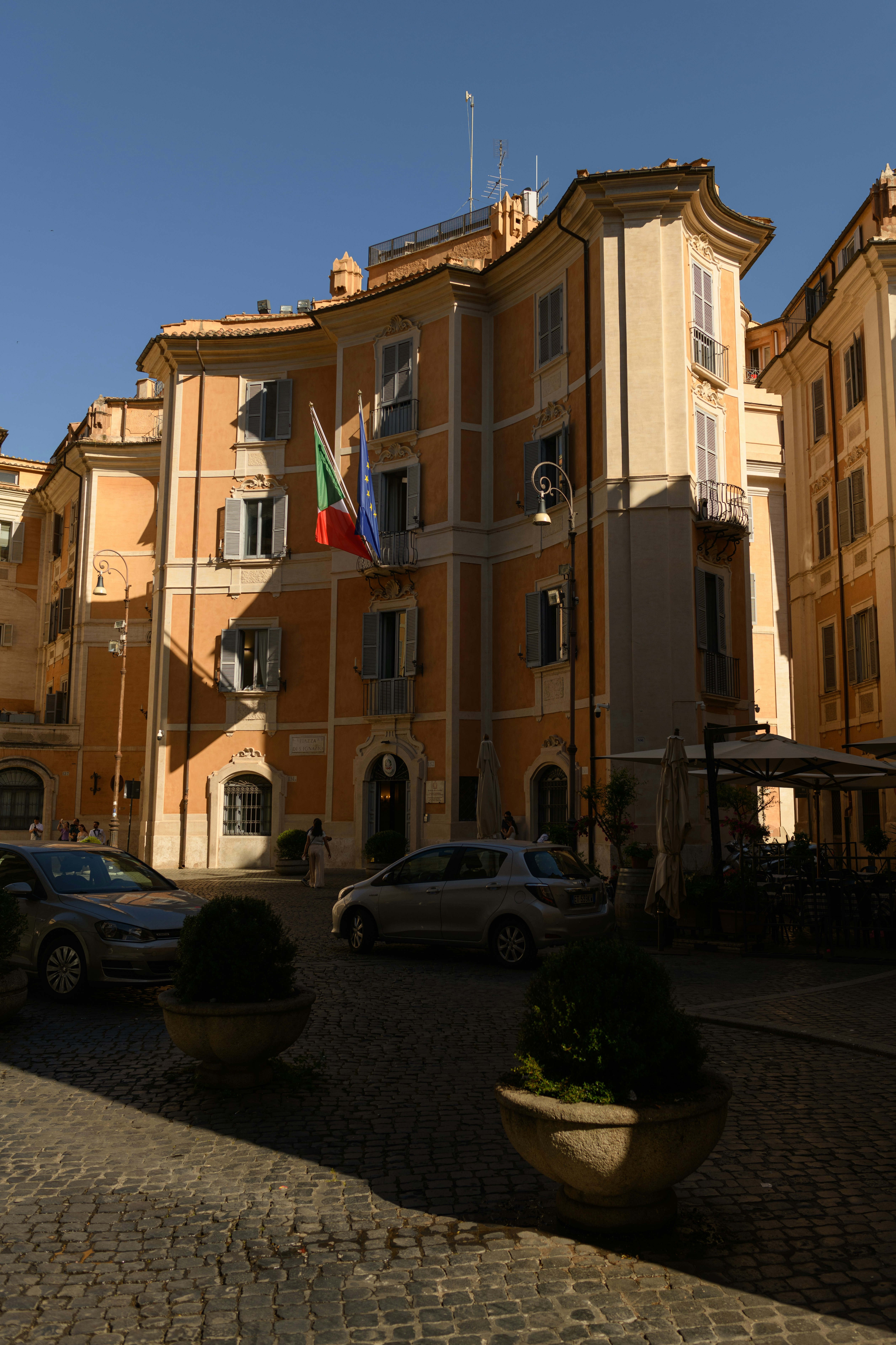 carros estacionados em frente a um grande prédio