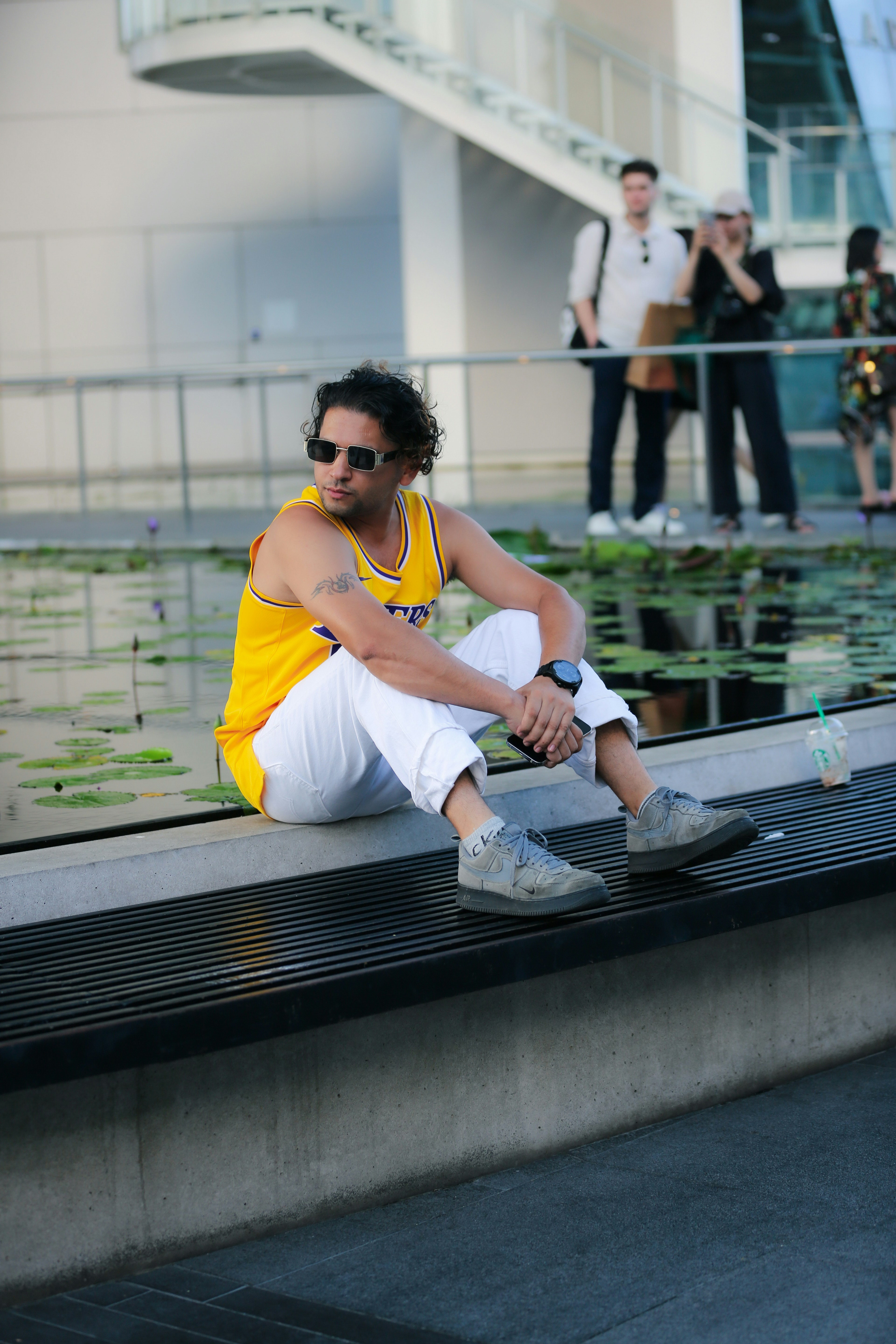 a man in a yellow shirt and white shorts sitting on a bench