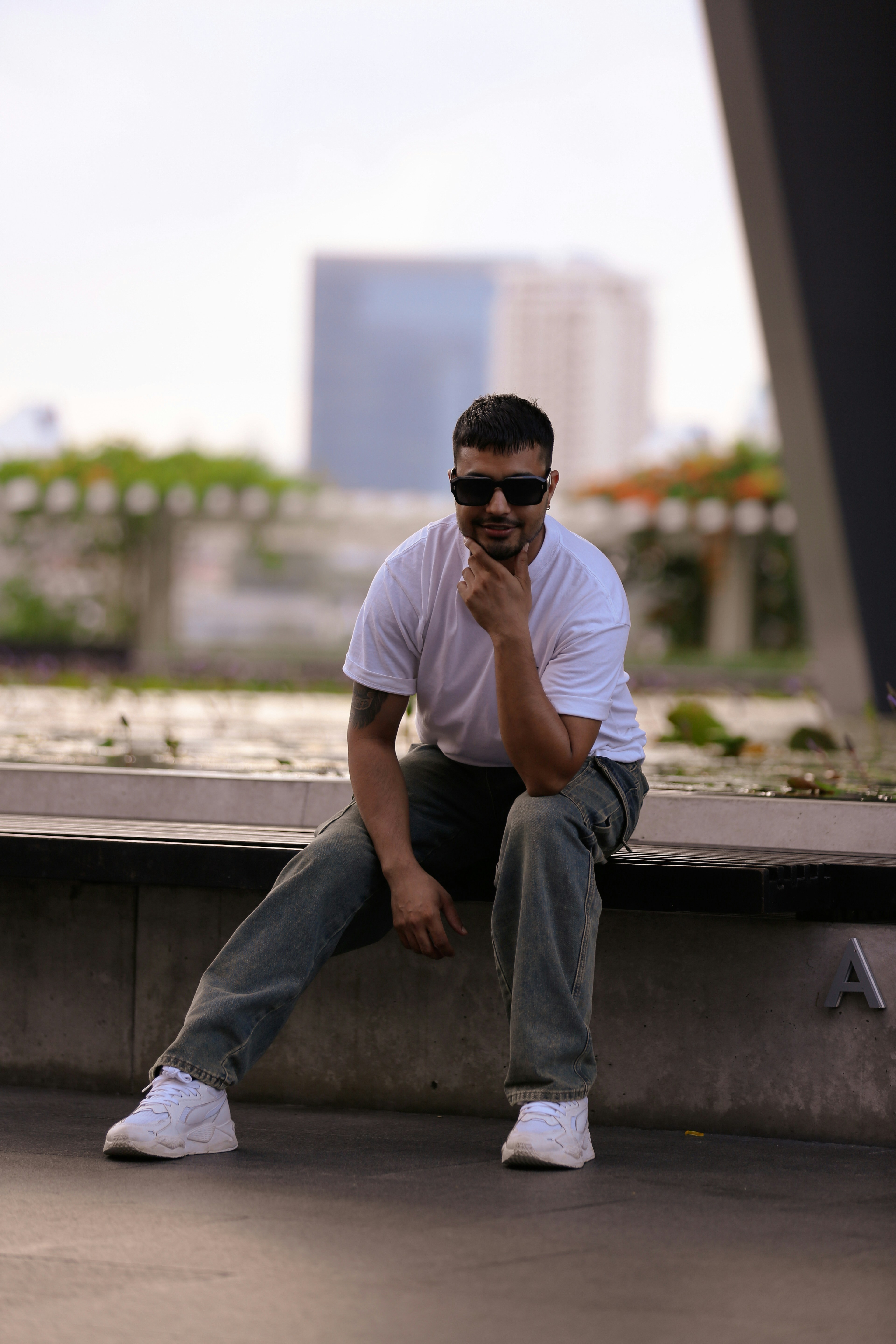 a man sitting on a ledge talking on a cell phone