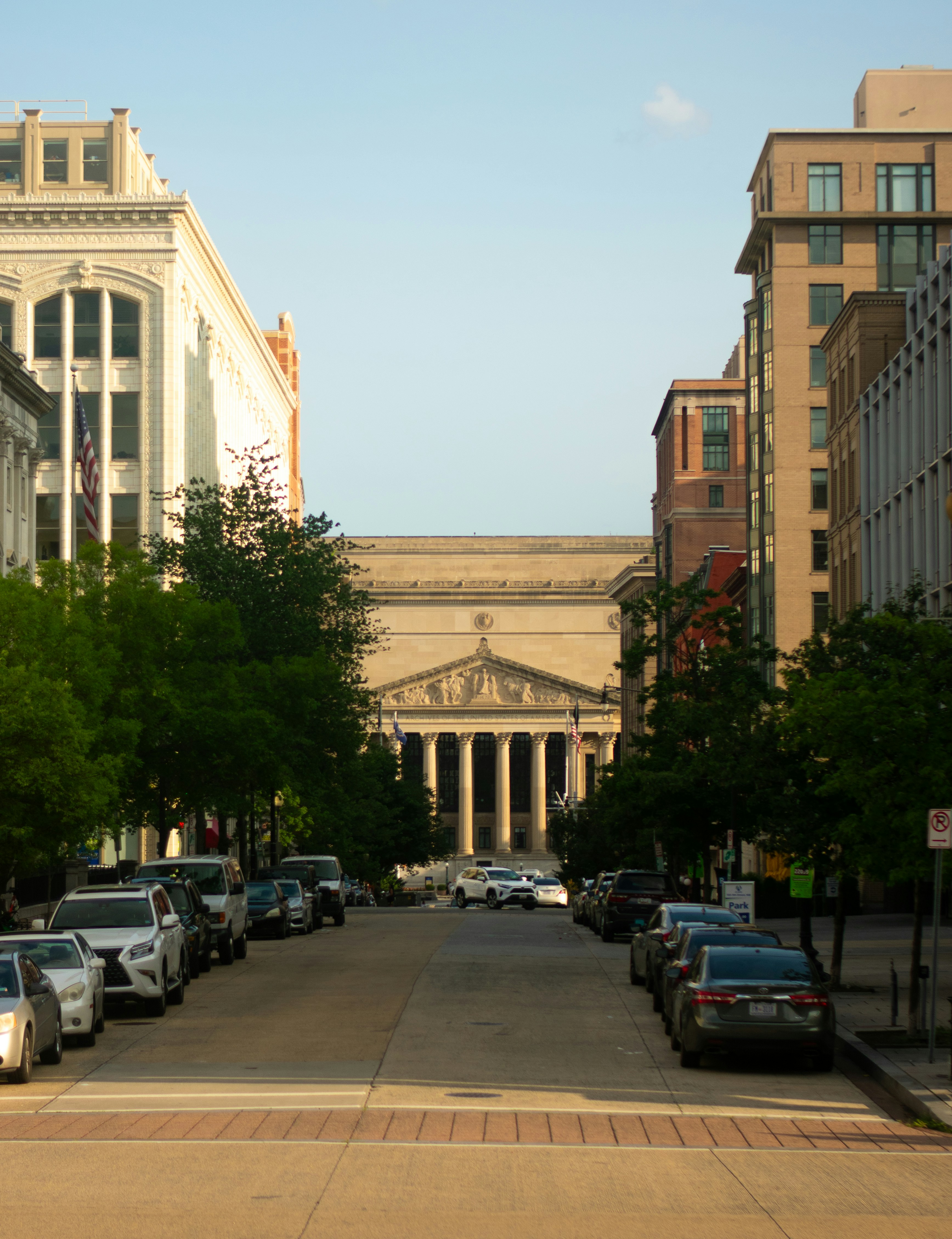 A city street lined with parked cars and tall buildings photo – Free ...