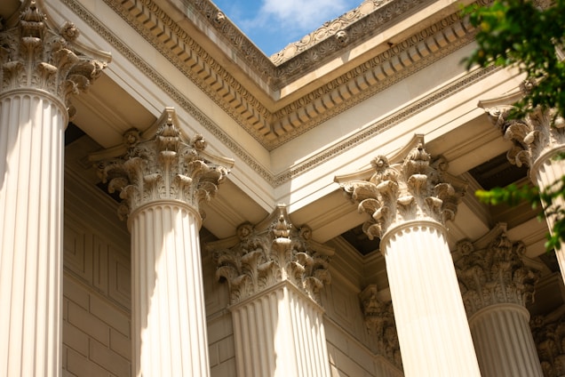 a close up of a building with columns and a sky background