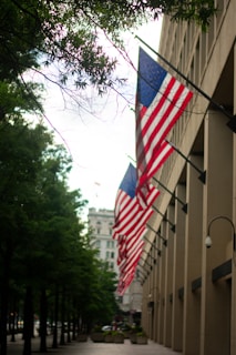 a row of american flags hanging from the side of a building