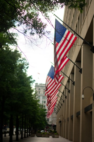 a row of american flags hanging from the side of a building