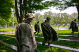 a group of statues of men in a park