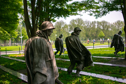 a group of statues of men in a park