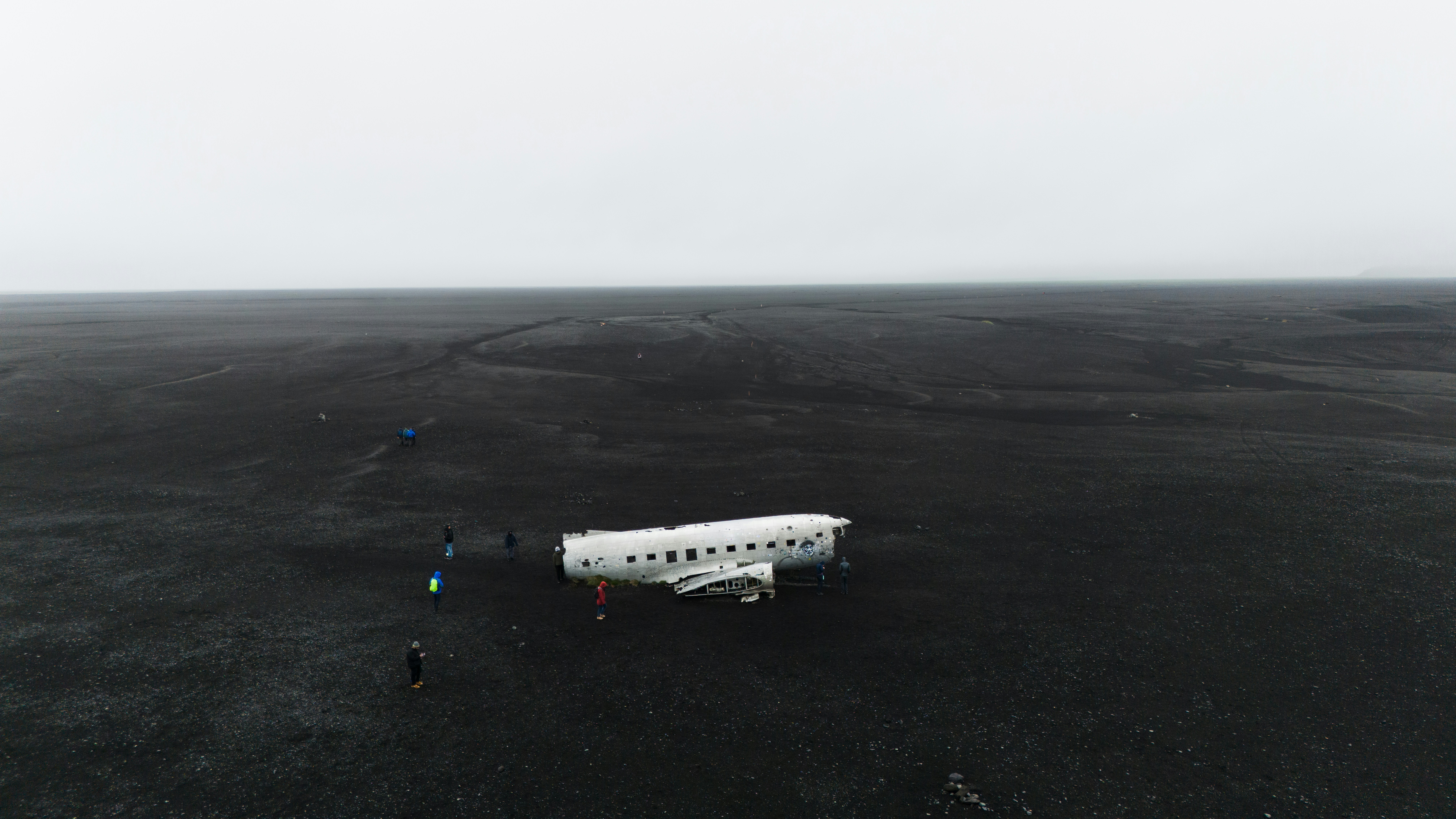 a small white airplane sitting on top of a black field
