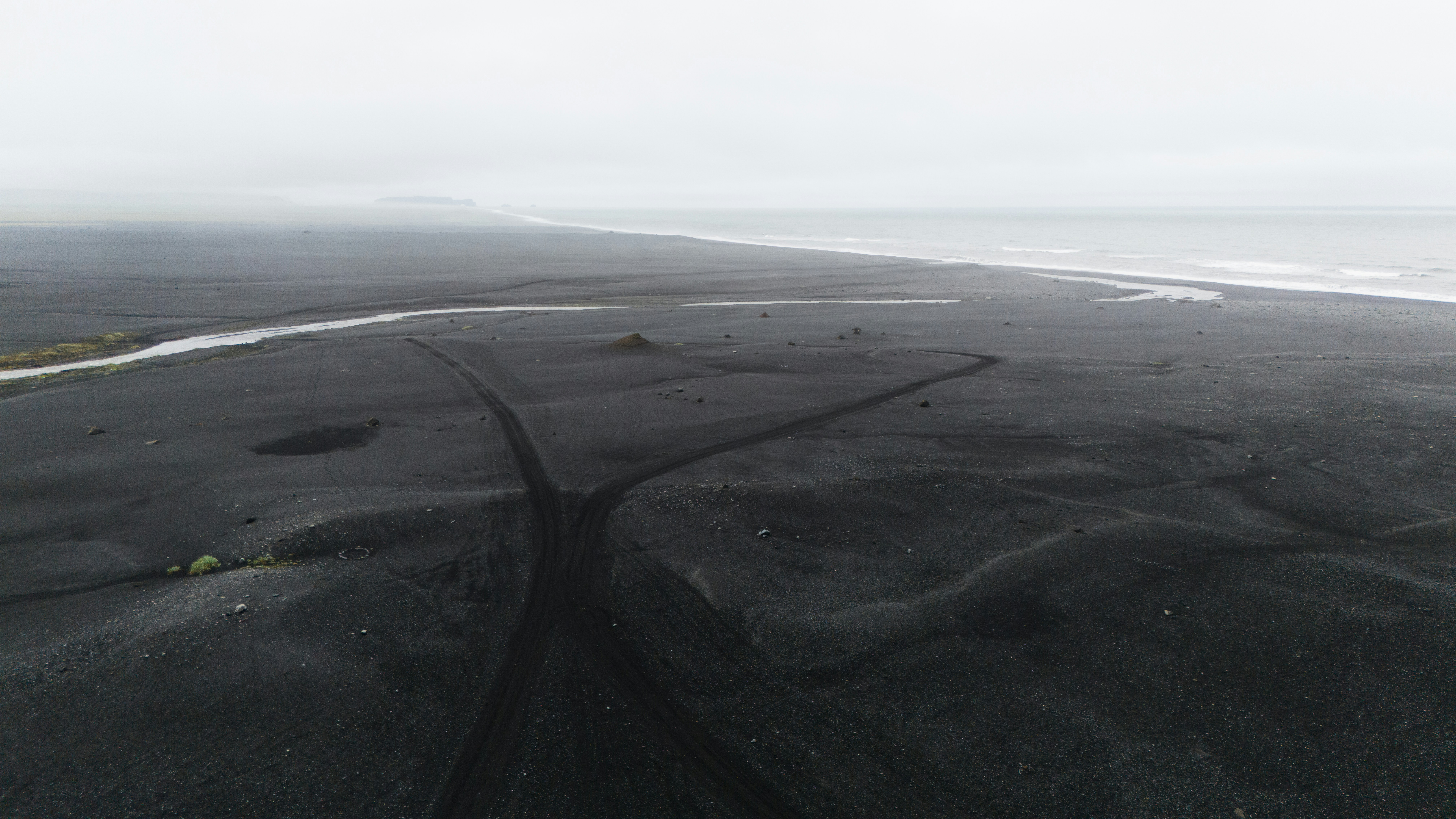 an aerial view of a black sand beach