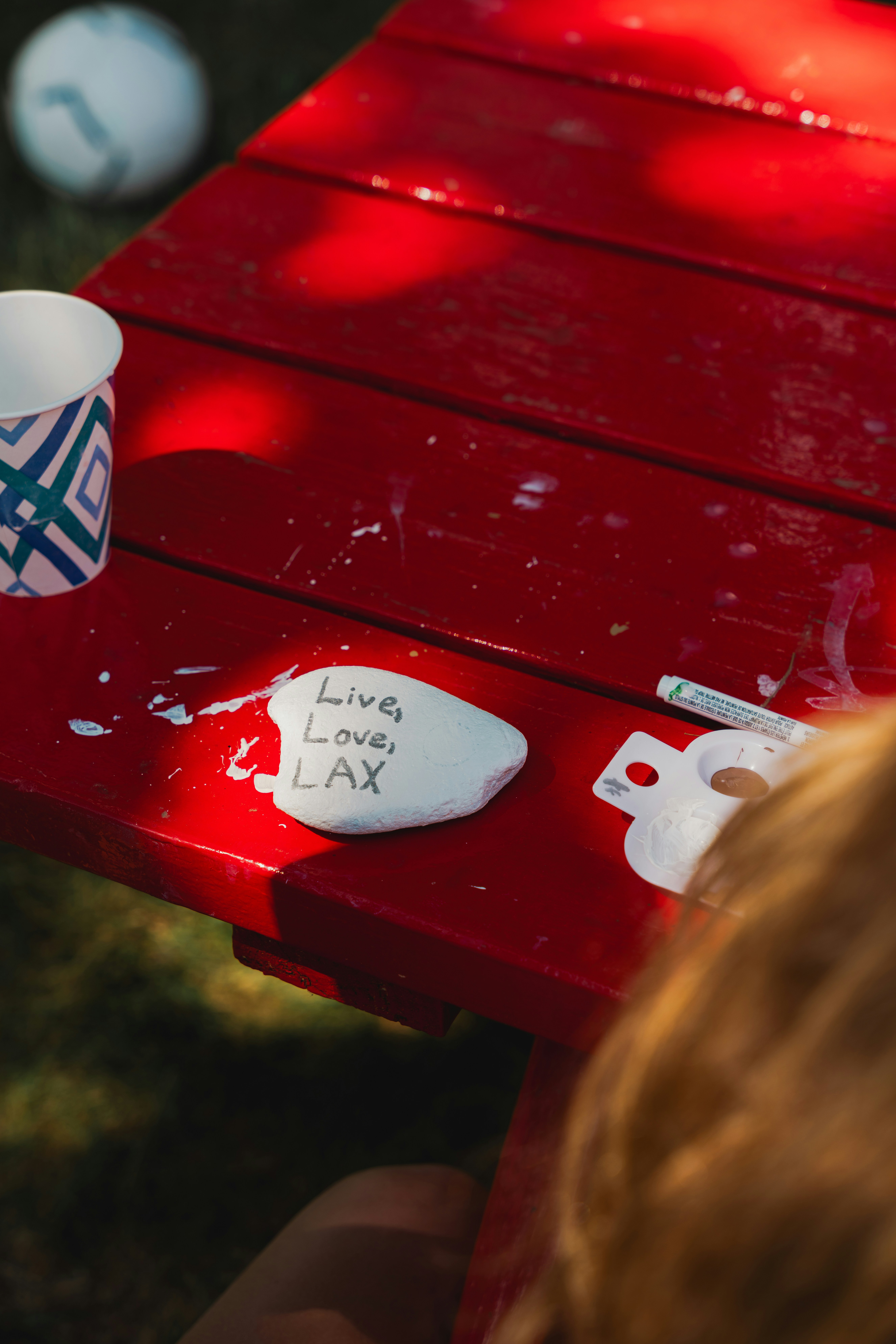 a red picnic table with a coffee cup on it
