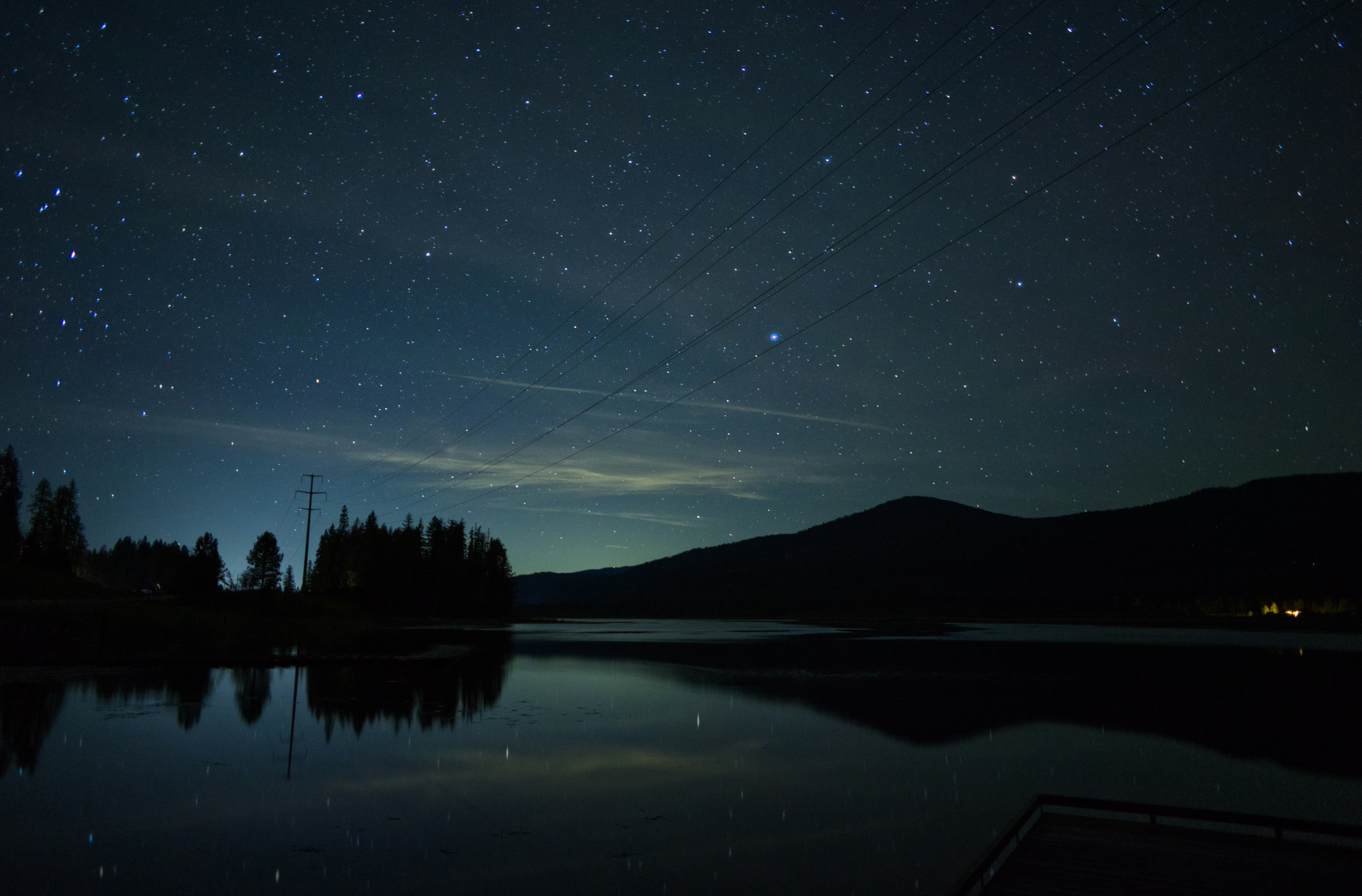 Le ciel nocturne se reflète dans l’eau calme d’un lac