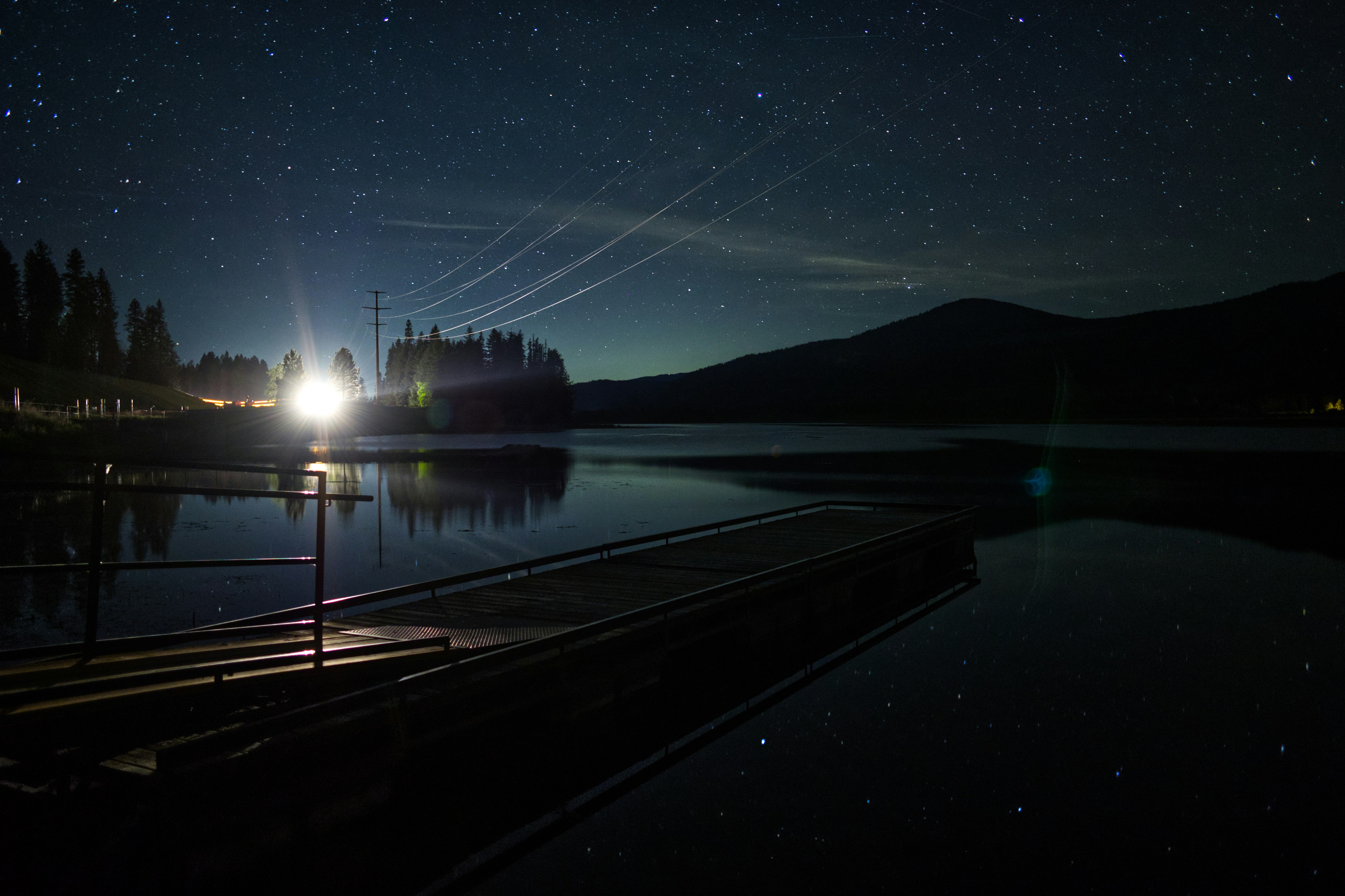 un quai de bateau la nuit avec les lumières allumées