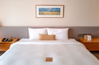 a bed with a white comforter and two nightstands