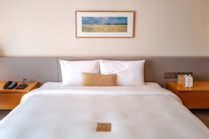 a bed with a white comforter and two nightstands