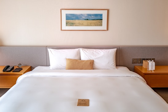 a bed with a white comforter and two nightstands