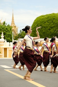 a group of women in thai garb dancing in a street