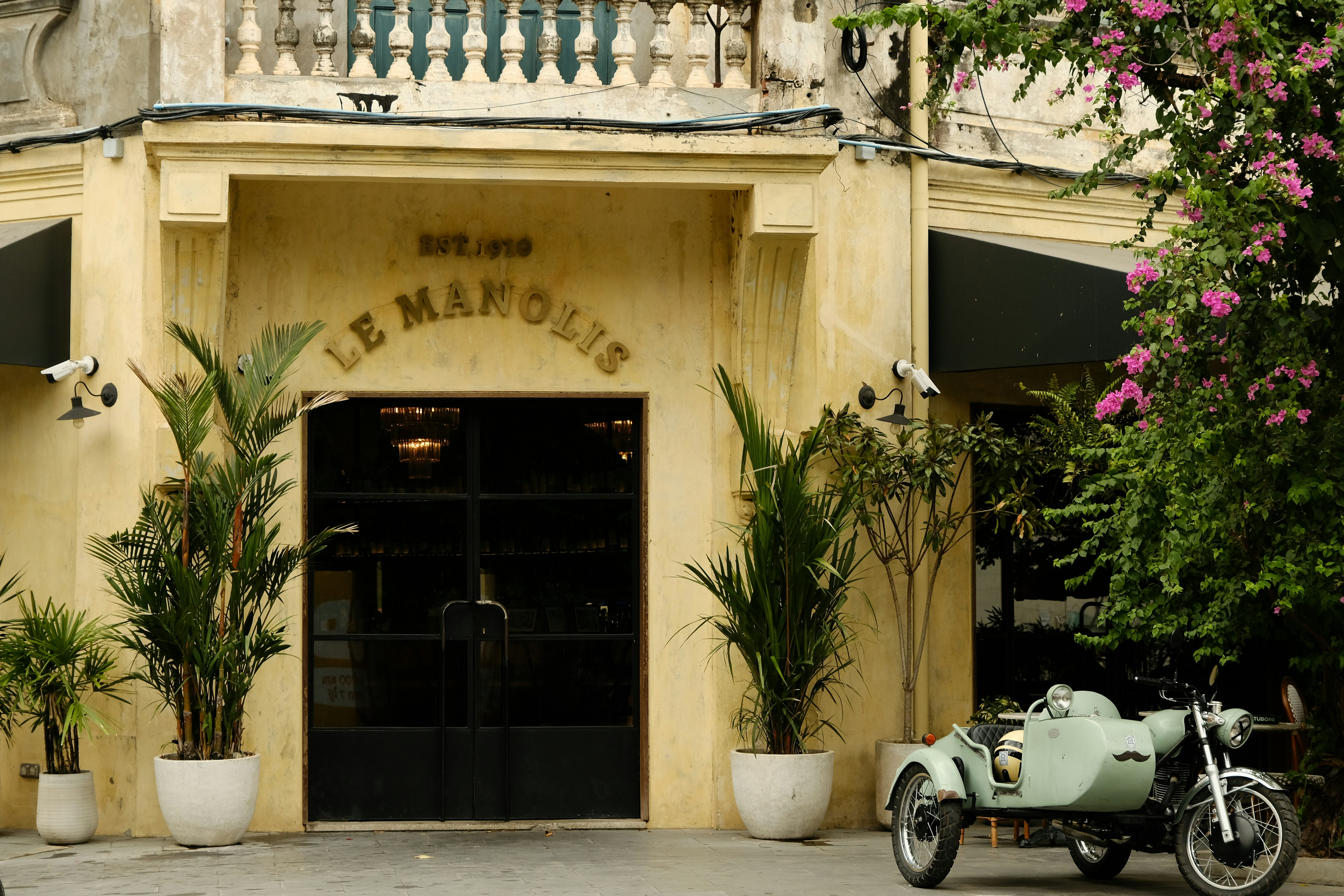 a motorcycle parked in front of a building, Classic Hotel.