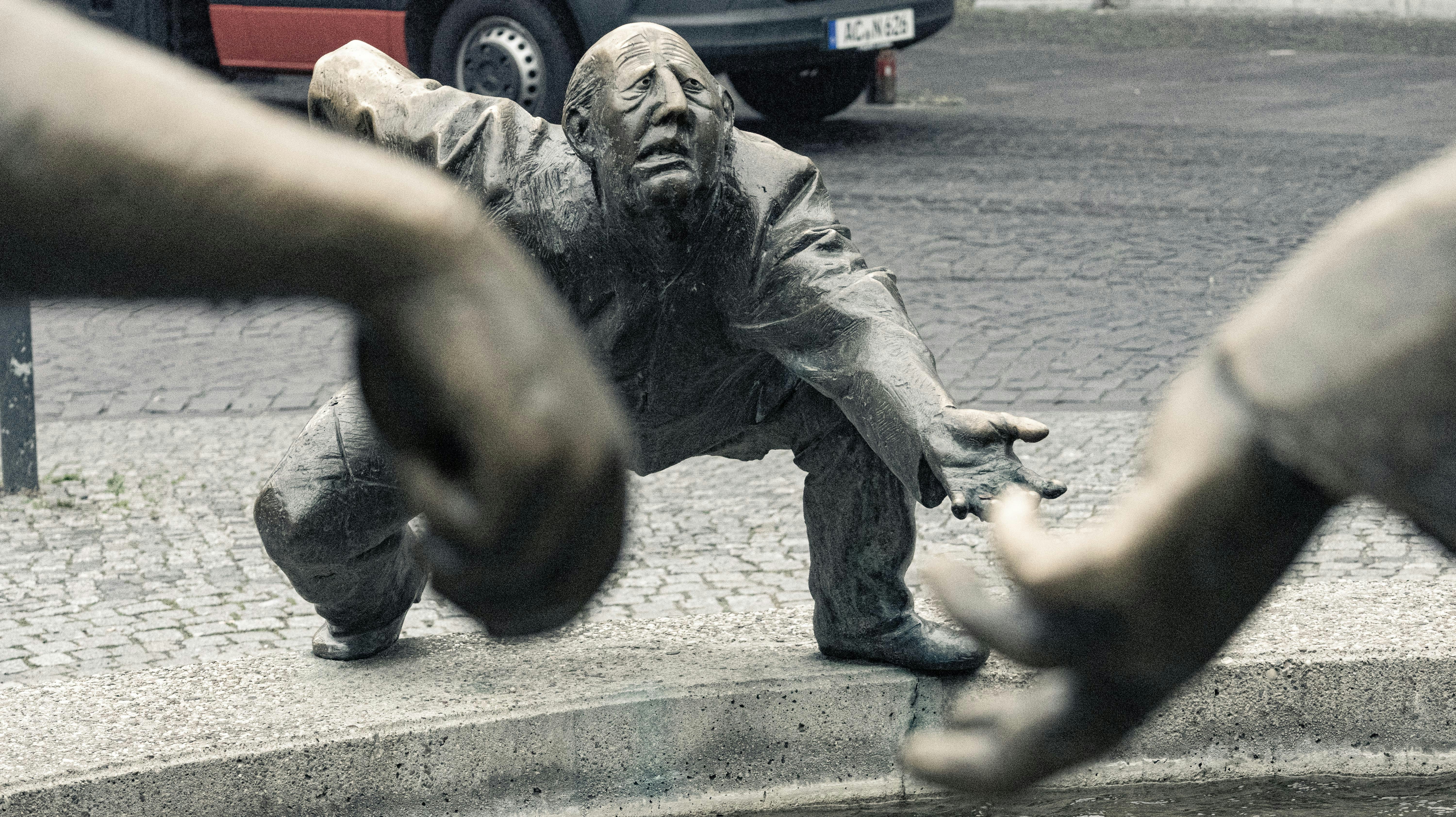 a statue of a man reaching for something