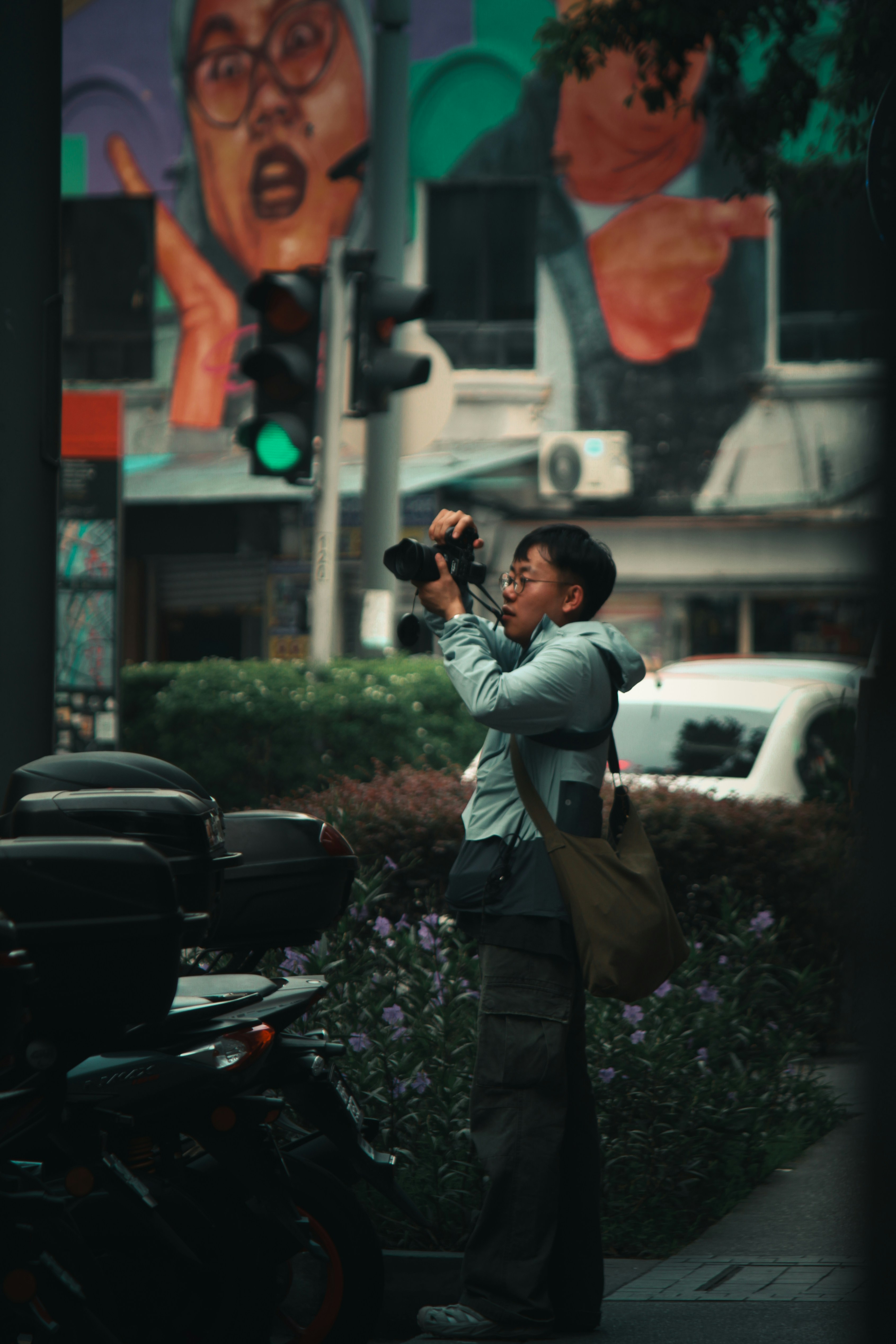 a woman taking a picture of a mural on the side of a building