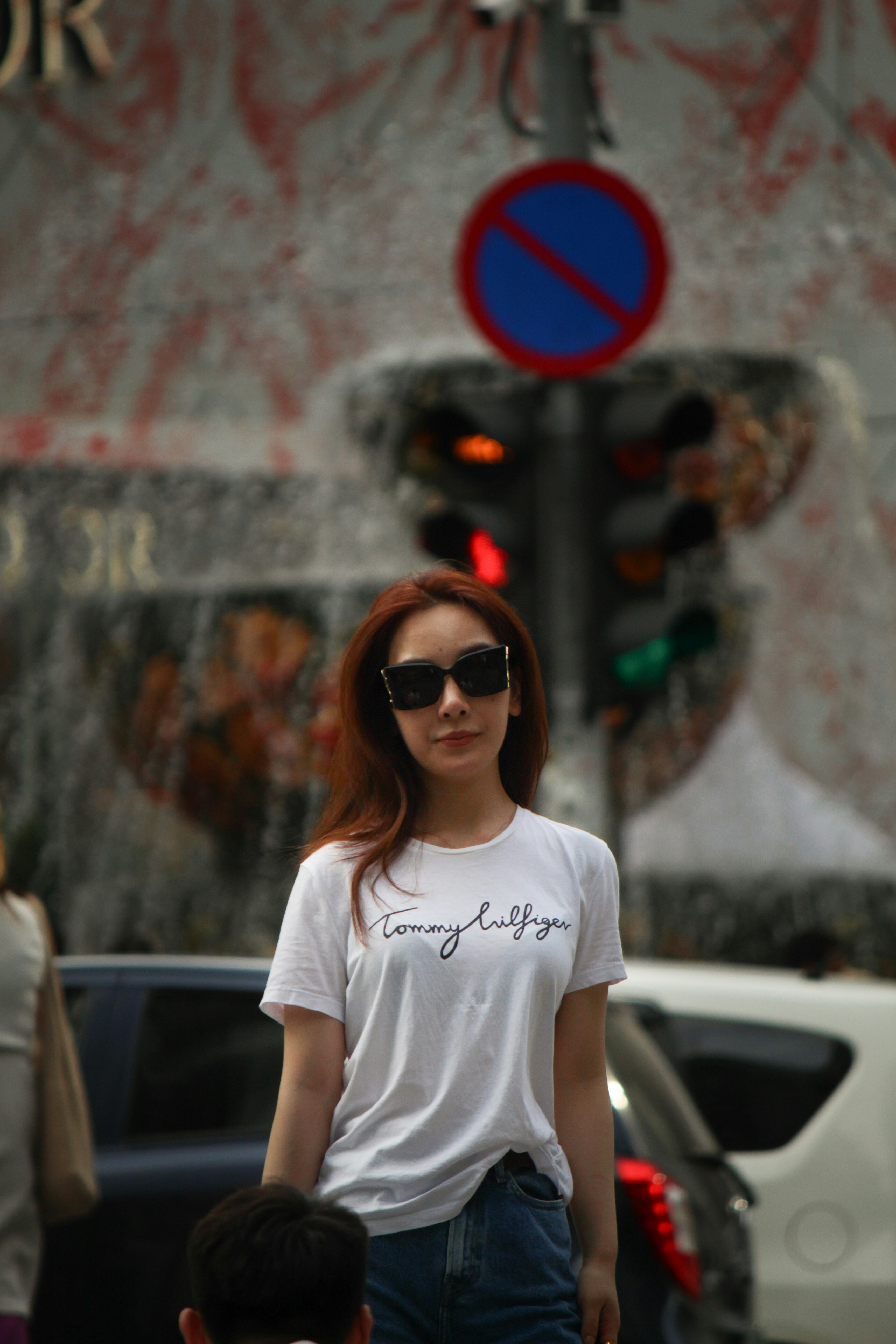 A woman in a white t - shirt is walking down the street photo – Free ...