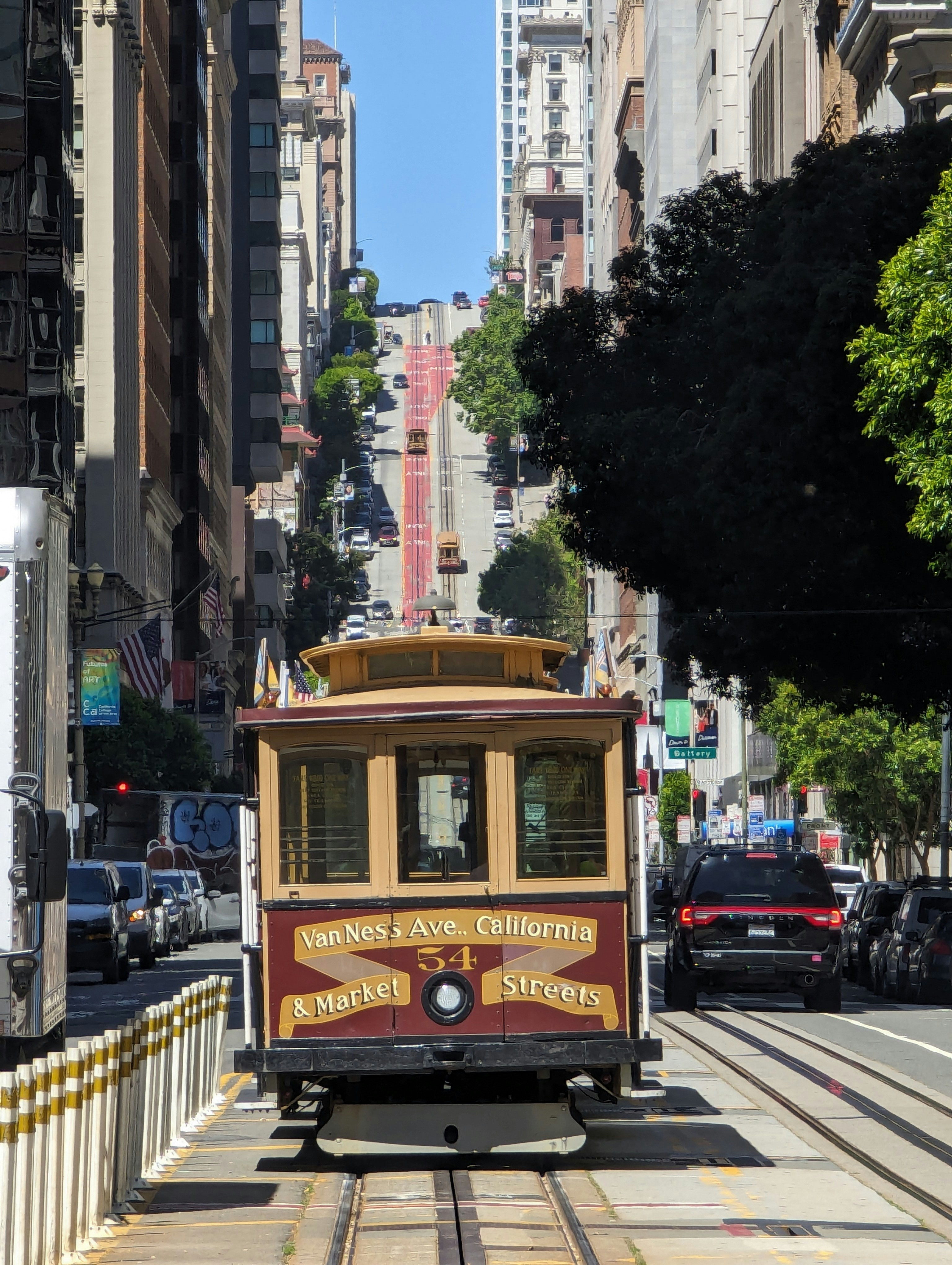 a trolley car traveling down a street next to tall buildings