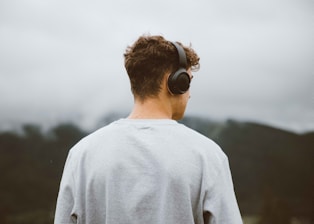 a man with headphones on looking at the mountains