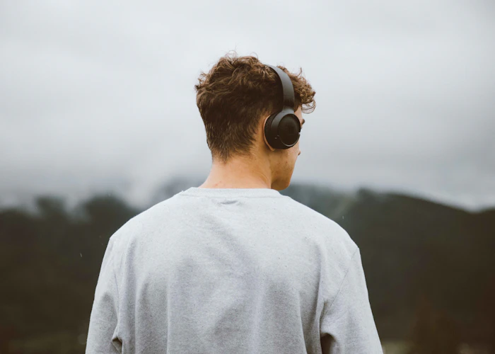 A man with headphones looking at the mountains