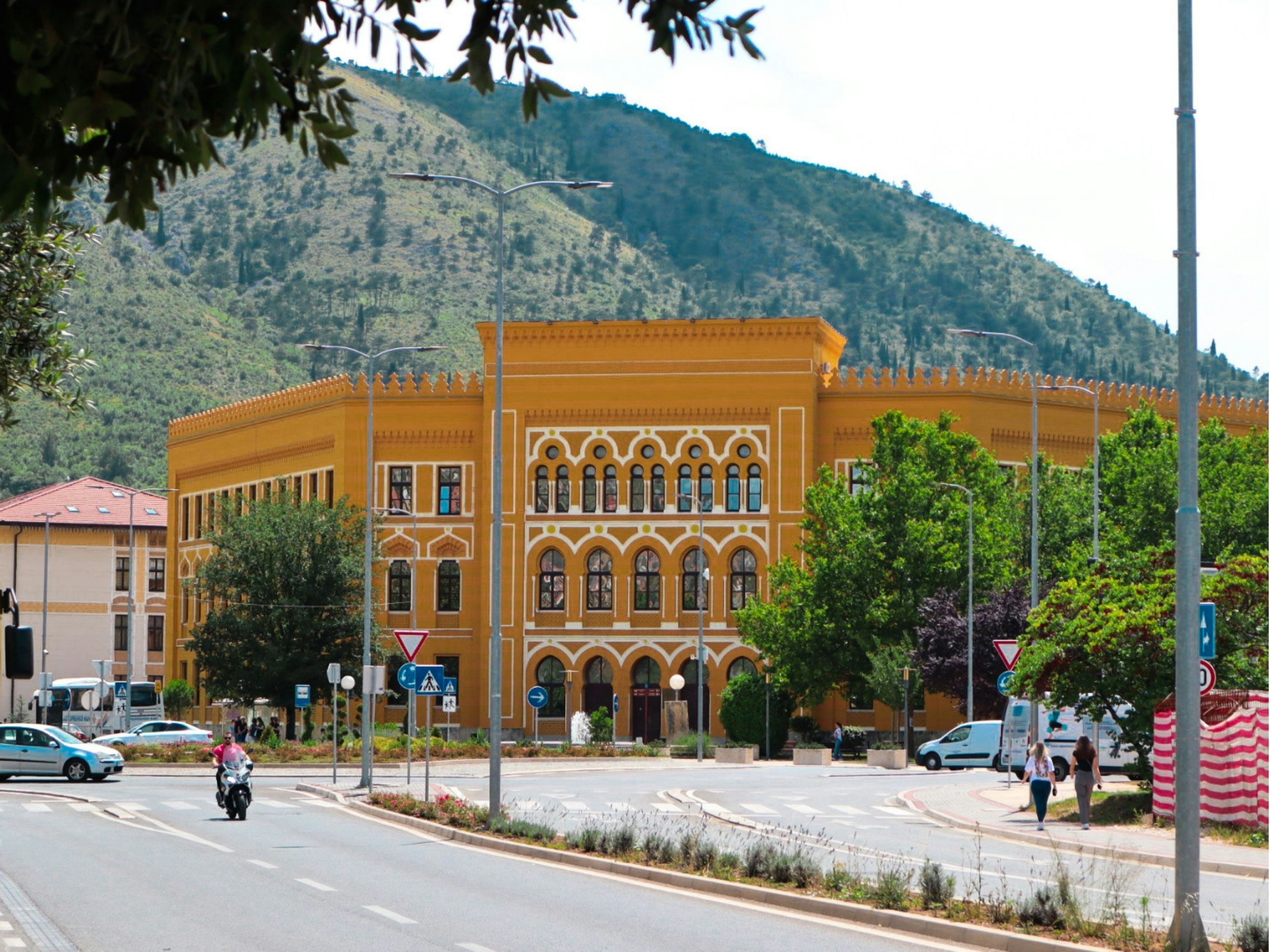 a large yellow building sitting on the side of a road, 