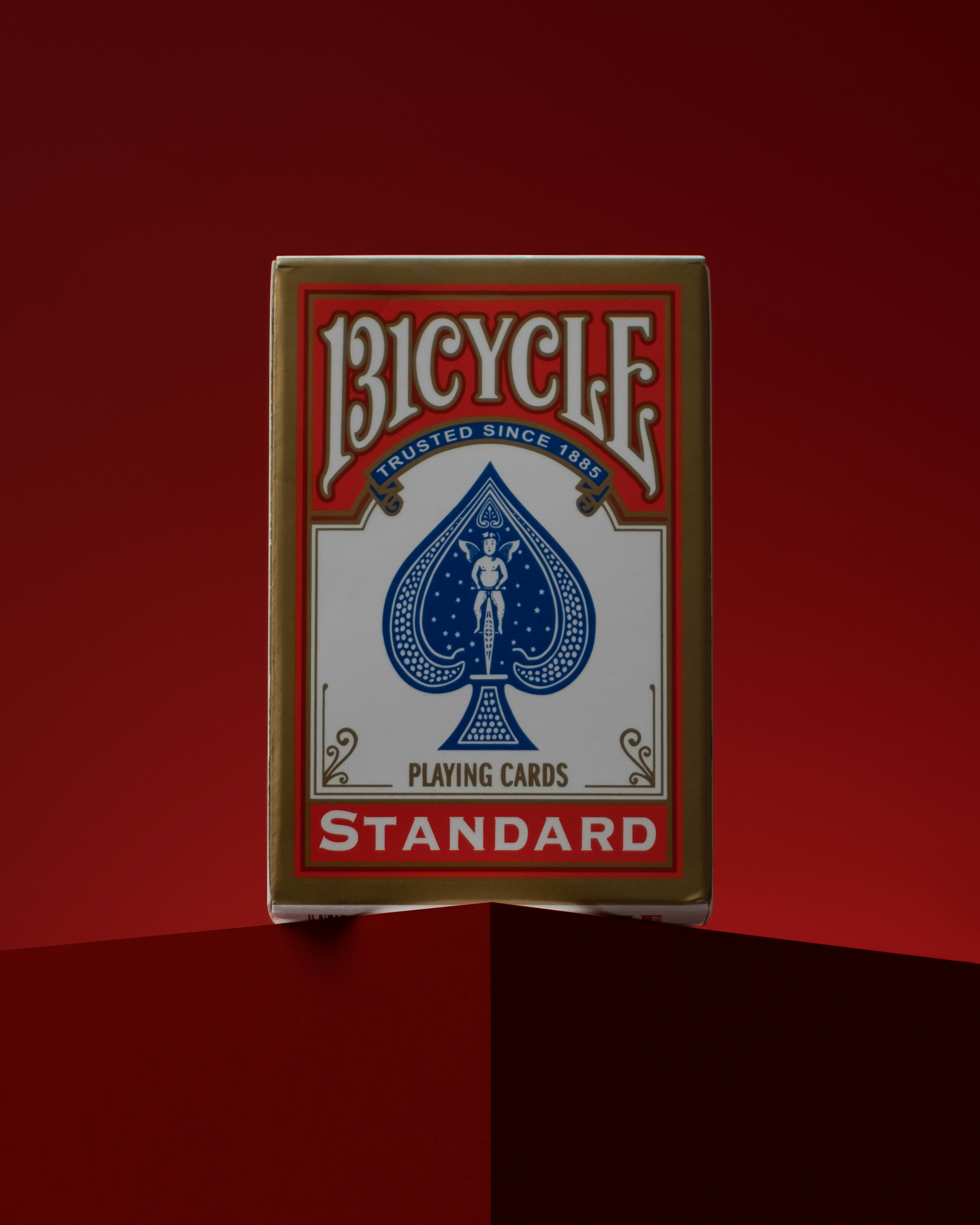 Ein Fahrrad-Spielkartenständer vor rotem Hintergrund