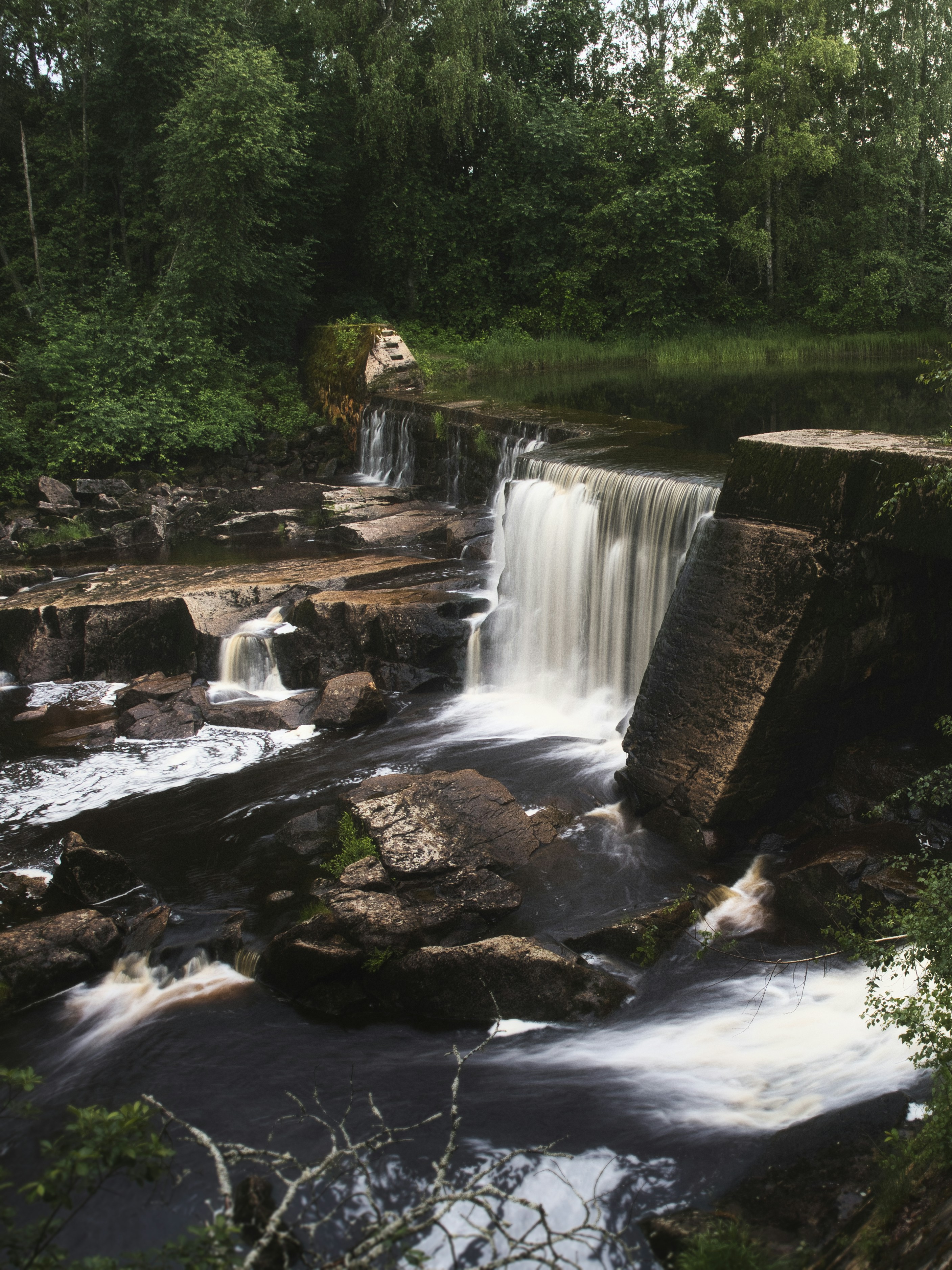 a small waterfall in the middle of a forest